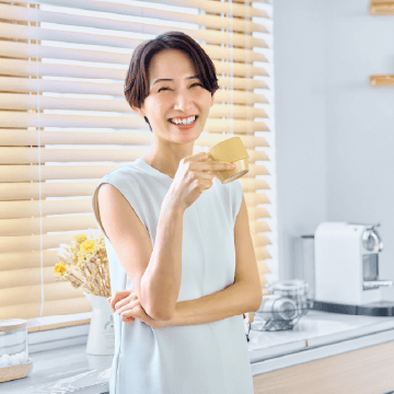 マグカップで飲み物を飲む笑顔の女性