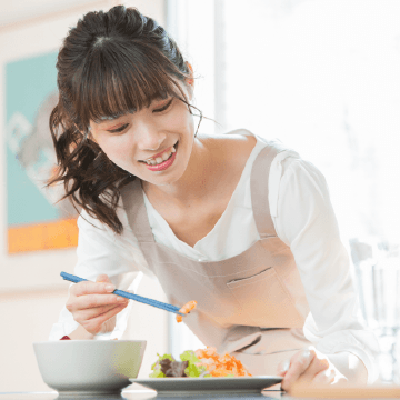 料理を盛り付ける女性